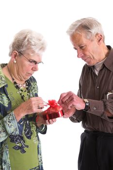 Loving senior couple opening a gift box of chocolates together