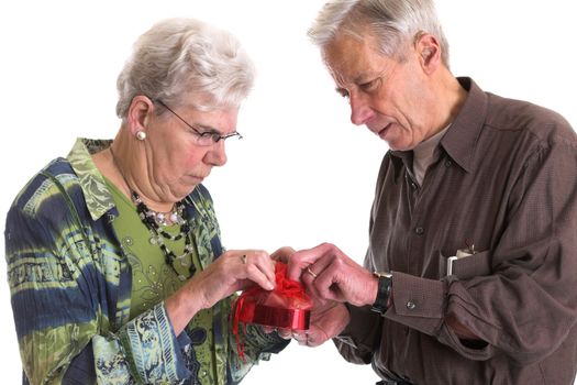 Senior man helping his wife to open the valentine chocolate box