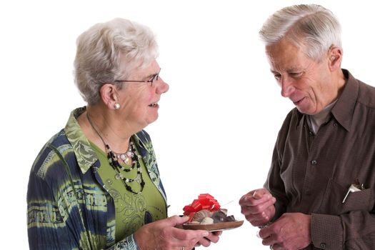 Elderly man looking happily at the chocolate heart his wife has brought him for valentines