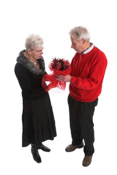 Senior couple during valentine; the man is giving his wife a nice valentine bouquet of flowers