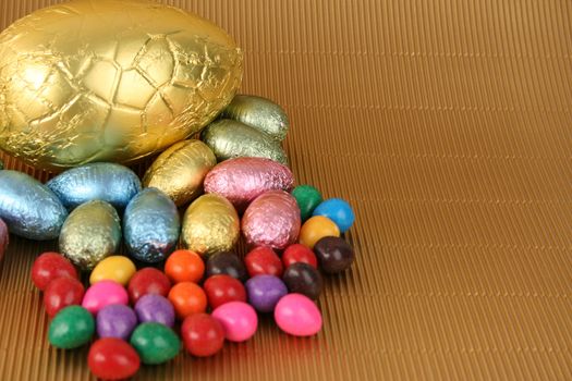 Various colors and shaped easter eggs on a gold background