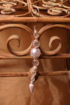 Crystal and Pearl Charm hanging from a rustic bench