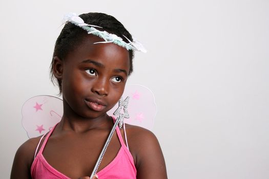 Young girl wearing a pink fairy costume with accessories