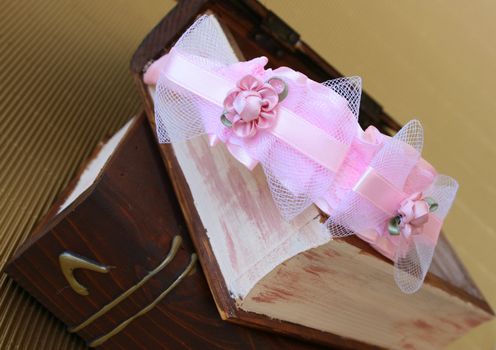 Pink Hair Accessories on a woonden jewellery box, on a golden background