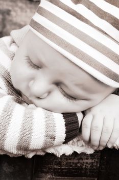 Beautiful baby boy sleeping in an antique trunk