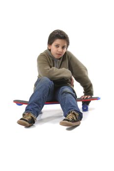 Cool boy sitting on a skate. Full body, white background. More pictures of this model at my gallery