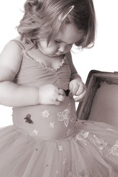 Toddler ballet girl looking at her costume