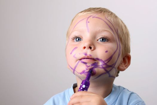 Laughing Toddler playing with colored pens making a mess