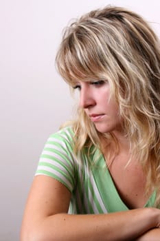 Blond Female model on a white background wearing a green top