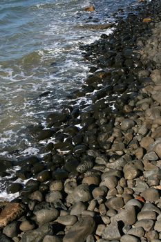 Half dry half wet pebbles with water ebb and flow