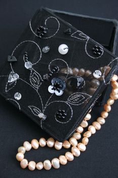 Black embroidered jewelery box with a string of pearls