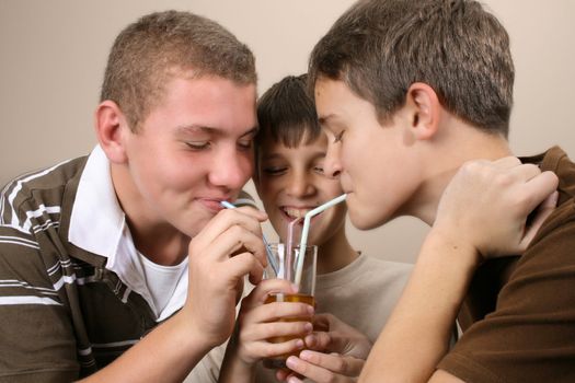 Three friends, sharing a glass of apple juice