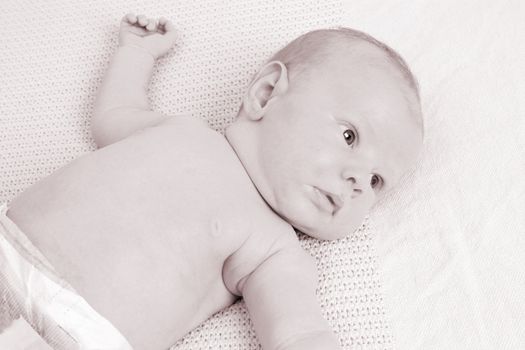 Month old baby boy on a light blanket. Sepia Tone