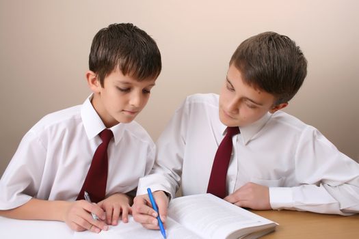 Teenage School boys busy with his homework, wearing uniform