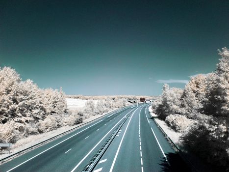 Infrared picture of an empty highway with blue sky