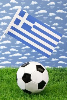 Soccerball on grass with greece national flag over sky background