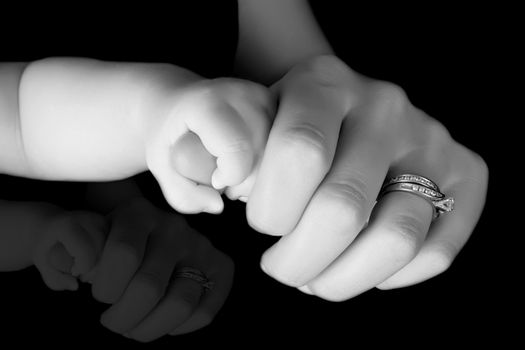 Caucasian mother and baby, baby holding mother's thumb