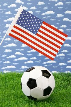 Soccerball on grass with american United States flag over sky background
