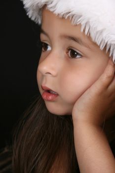 Cute little brunette girl wearing a christmas hat 