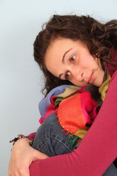 Brunette female wearing a pink top and colorful scarf