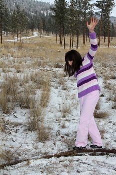 Young brunette teen playing in the field after the snowfall