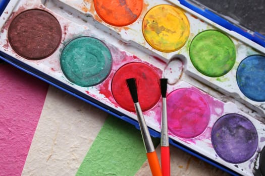 Paint Brushes, Paint and different colored handmade paper
