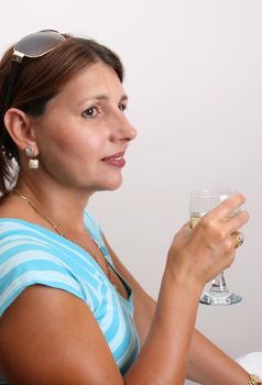 Adult Female Model wearing a blue top with a glass of wine