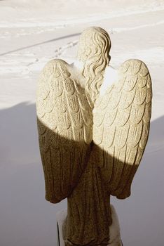 - stone angel figure on snow background