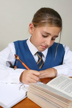 Teenage School girl busy with her homework, wearing uniform