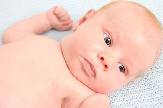 Month old baby boy on a light blue blanket 