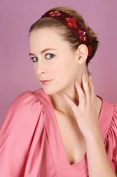 Beautiful blond female model wearing pink dress and hair accessories
