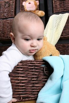 Six month old baby sitting infront of wooden drawers