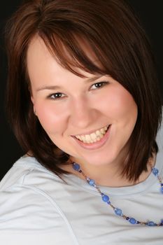 Headshot of beautiful brunette female on a black background