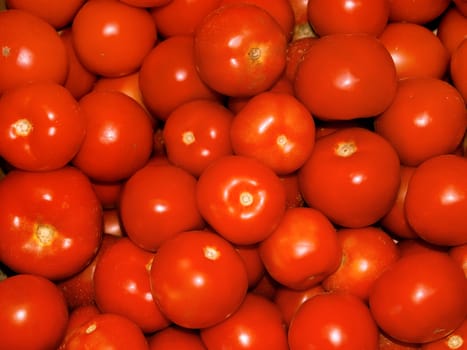 A lot of ripe red tomatoes on the heap as a background