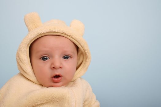Two month old baby boy wearing a soft animal suit 