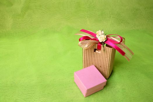 Pink gift box and brown gift bag with ribbons