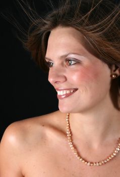 Beautiful young woman with naked shoulders and pearls