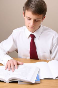 Teenage School boy busy with his homework, wearing uniform