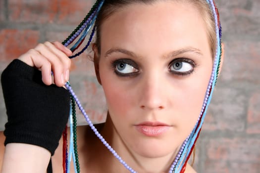 Beautiful model with blue eyes holding strings of beads