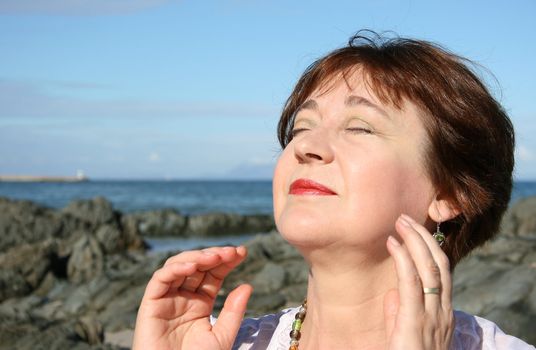 Beautiful mature brunette female on the beach