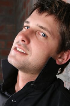 Male model against a rough brick wall background