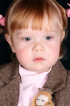 Toddler girl with chubby cheeks wearing a stylish jacket