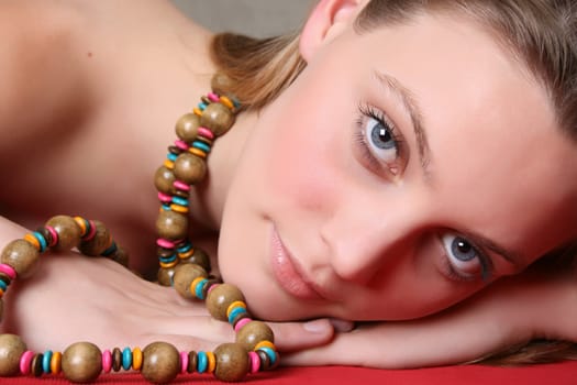 Beautiful female model with blue eyes and a string beads 