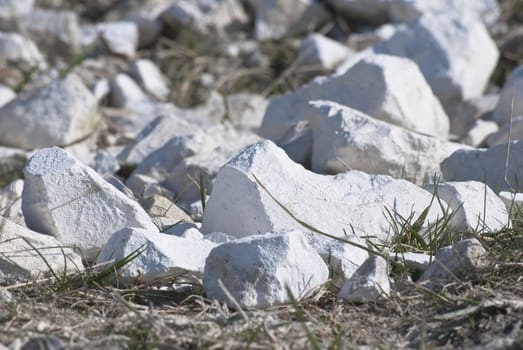 Natural chalk fragments scattered on the ground, having crumbled from a cliff face.  