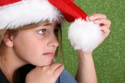 Bored teenager wearing a christmas hat on green background