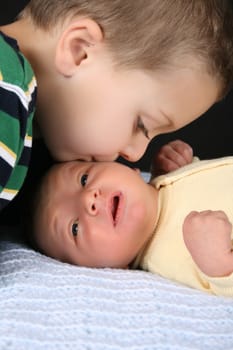 Big brother giving his baby brother a kiss