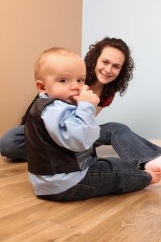 Mother and son playing indoors on a wooden floor