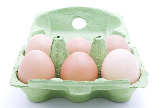 Half a dozen eggs in a green carton viewed from the front.  White background.