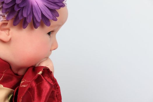 Beautiful baby girl wearing a headband with purple flower