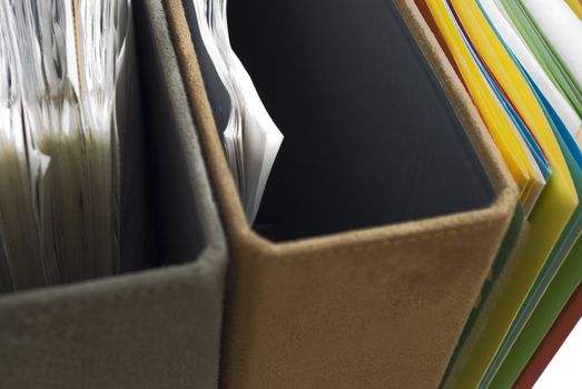 Close-up of faux suede and coloured cardboard folders and files viewed from above.